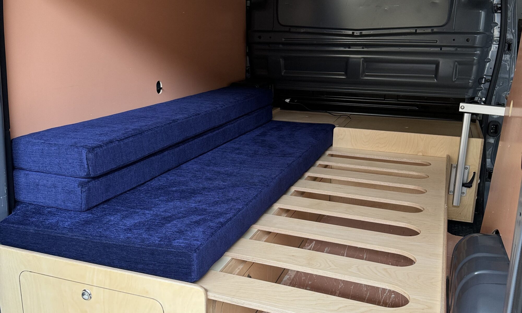 Banquette lit peigne installé dans un Renault Trafic avec aménagement amovible